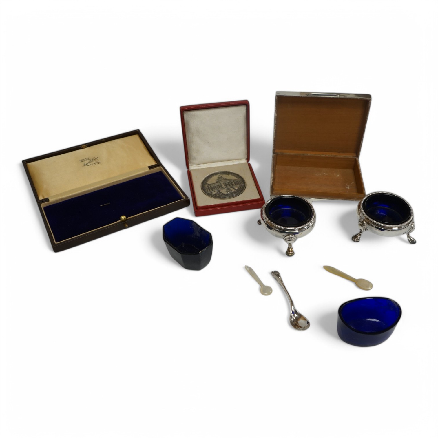 A pair of late George II silver bun salts, David Mowden, London 1759, with blue glass liners, a 1950's silver mounted cigarette box, 11.5cm and seven other items including condiment spoons and a cased Romanian medallion.